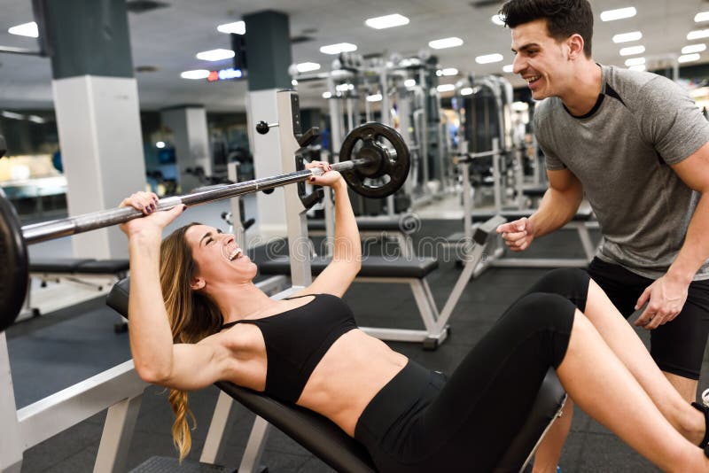 Persönlicher Trainer, welche einer jungen Frau hilft, Gewichte anzuheben stockbilder Persönlicher Trainer, welche einer jungen Frau hilft, Gewichte anzuheben stockbilder