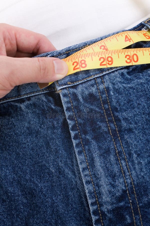 A blue jean and ruler, concept of weight loss. A blue jean and ruler, concept of weight loss