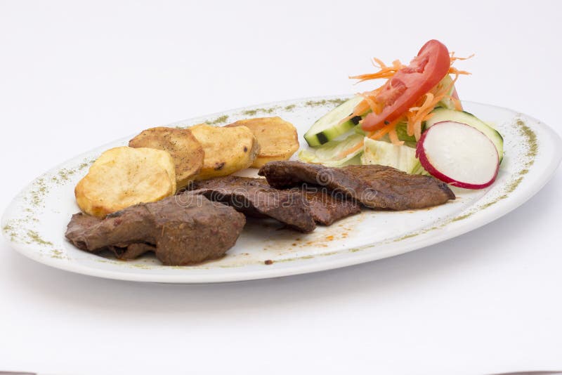 Peruansk maträtt: anticuchos, grillat skewered nötkötthjärtakött med den kokta potatisen och sallad arkivbild Peruansk maträtt: anticuchos, grillat skewered nötkötthjärtakött med den kokta potatisen och sallad arkivbild