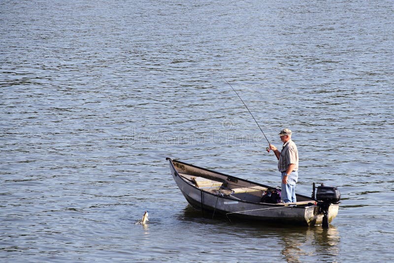 Pesca del hombre de un bote pequeño fotografía de archivo libre de regalías