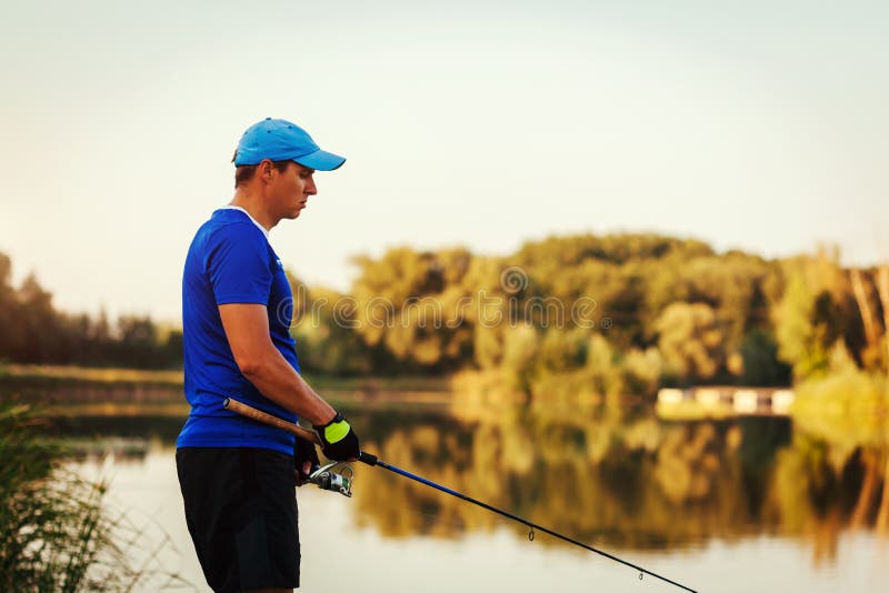 Pesca del hombre joven en el río del verano en la puesta del sol Trastorno triste del fiserman debido a mala captura fotografía de archivo libre de regalías Pesca del hombre joven en el río del verano en la puesta del sol Trastorno triste del fiserman debido a mala captura fotografía de archivo libre de regalías