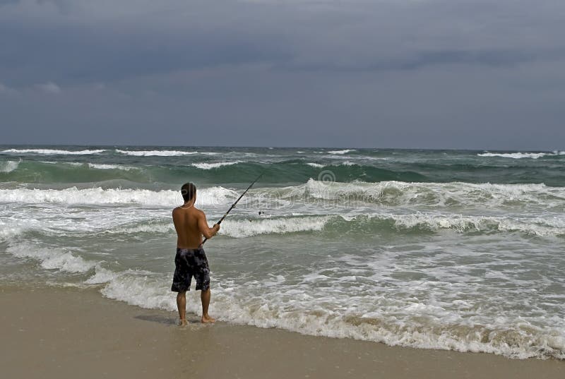 Pesca del puntello dell'uomo durante la tempesta fotografia stock libera da diritti Pesca del puntello dell'uomo durante la tempesta fotografia stock libera da diritti