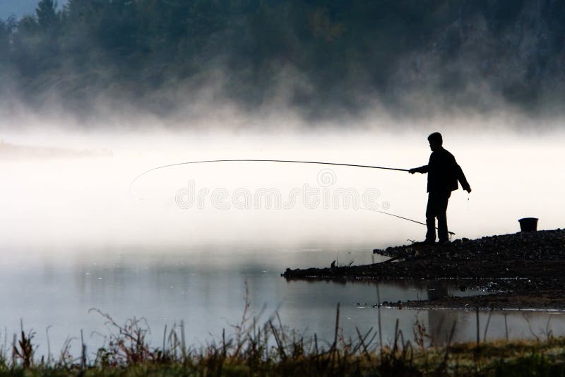 Pesca dell'uomo alla riva del fiume