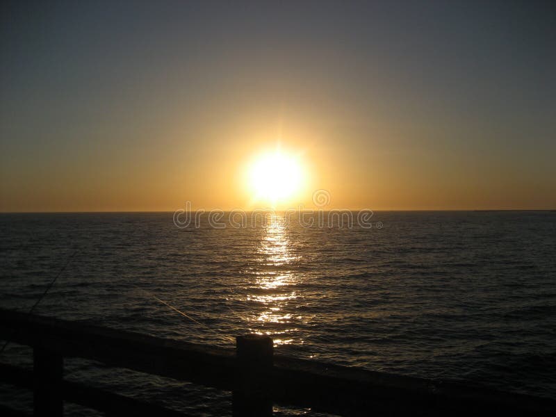 Pesca no por do sol no cais do perto do oceano fotografia de stock royalty free Pesca no por do sol no cais do perto do oceano fotografia de stock royalty free