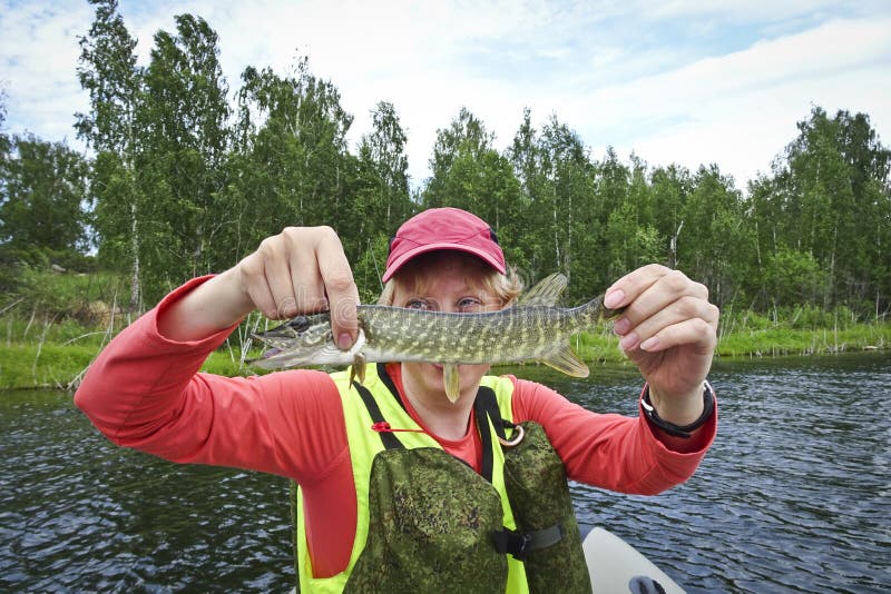 A pesca é uma grande captura Peixes travados nas mãos de um pescador feliz fotografia de stock A pesca é uma grande captura Peixes travados nas mãos de um pescador feliz fotografia de stock