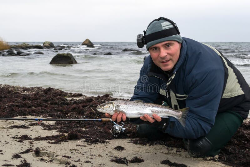 Pescador com truta-do-mar no inverno imagens de stock