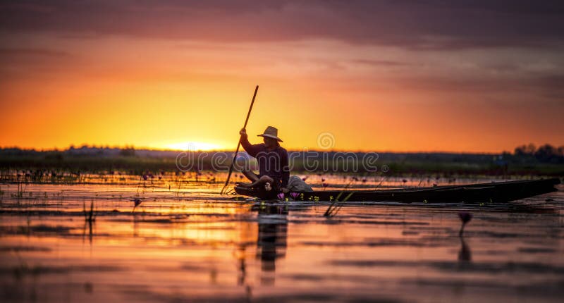 Pescador em seu barco tradicional no nascer do sol foto de stock royalty free Pescador em seu barco tradicional no nascer do sol foto de stock royalty free