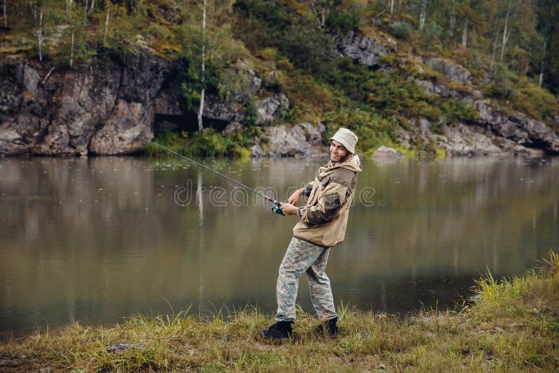 Pescador en los pescados de las capturas del río foto de archivo Pescador en los pescados de las capturas del río foto de archivo