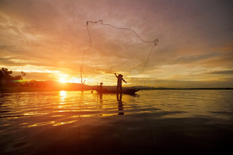 Pescador Fishing da silhueta usando a rede no barco com luz do sol em Tail?ndia na manh?, no conceito da natureza e da cultura fotos de stock Pescador Fishing da silhueta usando a rede no barco com luz do sol em Tail?ndia na manh?, no conceito da natureza e da cultura fotos de stock