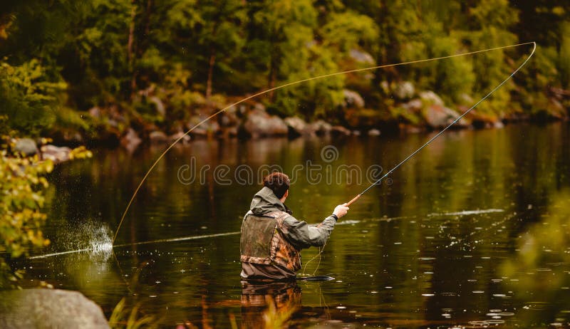 Pescador que pesca com mosca-da-serra no rio da montanha