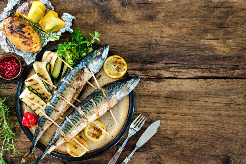 Pescados asados a la parrilla de la caballa con las patatas cocidas imágenes de archivo libres de regalías Pescados asados a la parrilla de la caballa con las patatas cocidas imágenes de archivo libres de regalías
