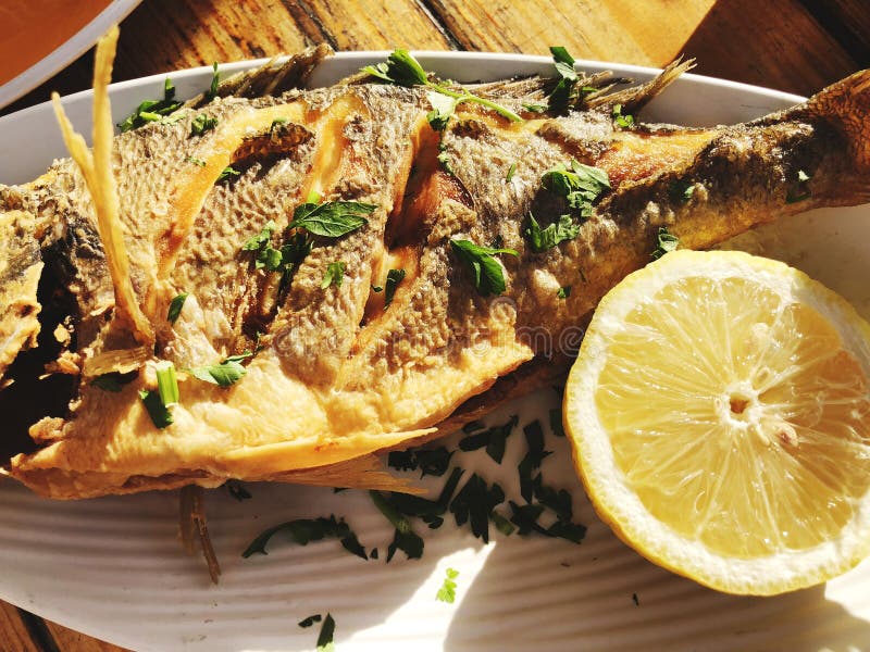 Pescados asados a la parrilla fritos deliciosos en una placa en un restaurante foto de archivo libre de regalías Pescados asados a la parrilla fritos deliciosos en una placa en un restaurante foto de archivo libre de regalías