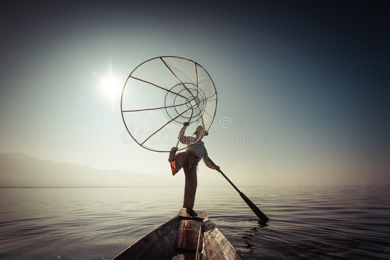 Pescados de cogida del pescador birmano de la manera tradicional Lago Inle, Myanmar fotografía de archivo libre de regalías Pescados de cogida del pescador birmano de la manera tradicional Lago Inle, Myanmar fotografía de archivo libre de regalías