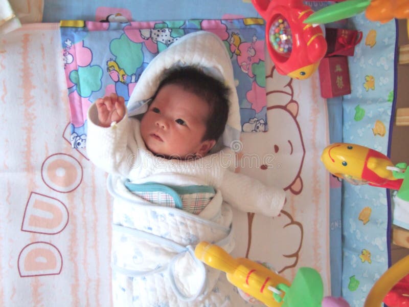 Baby and toy fish on a bed. Baby and toy fish on a bed