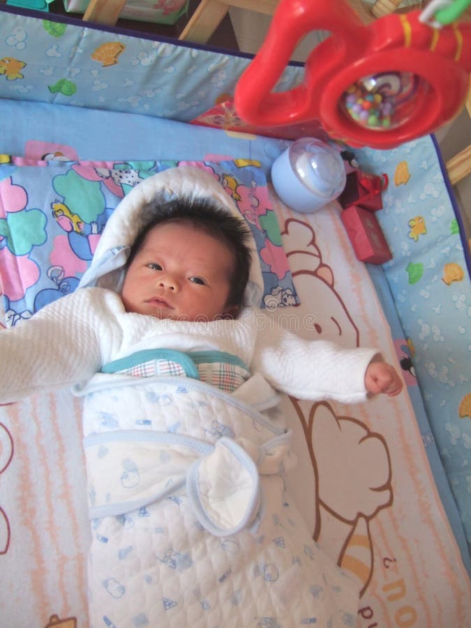 Baby and toy fish on a bed. Baby and toy fish on a bed