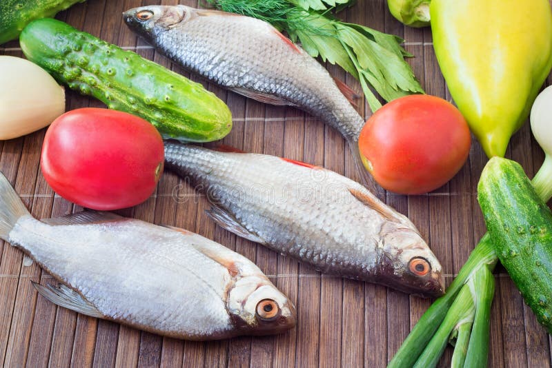 Pescados y componentes para su preparación: verduras, especias, par foto de archivo Pescados y componentes para su preparación: verduras, especias, par foto de archivo