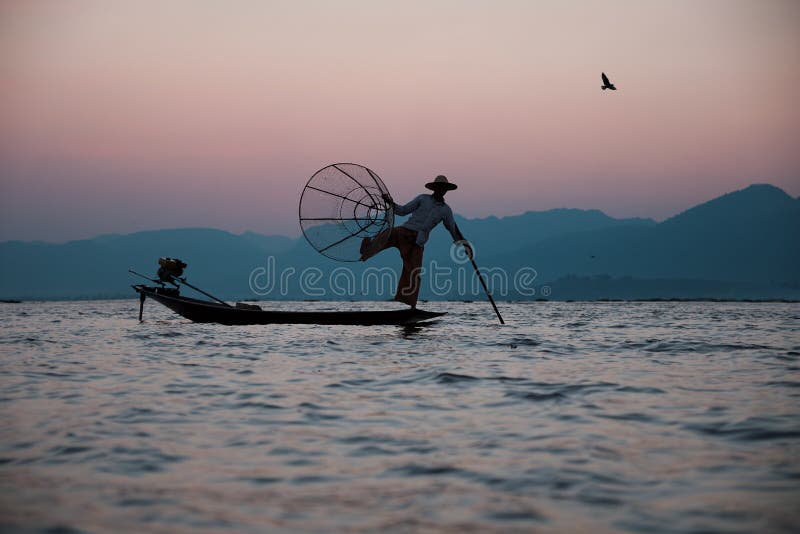 Pescatore tradizionale sul lago Inle nel Myanmar fotografia stock libera da diritti Pescatore tradizionale sul lago Inle nel Myanmar fotografia stock libera da diritti