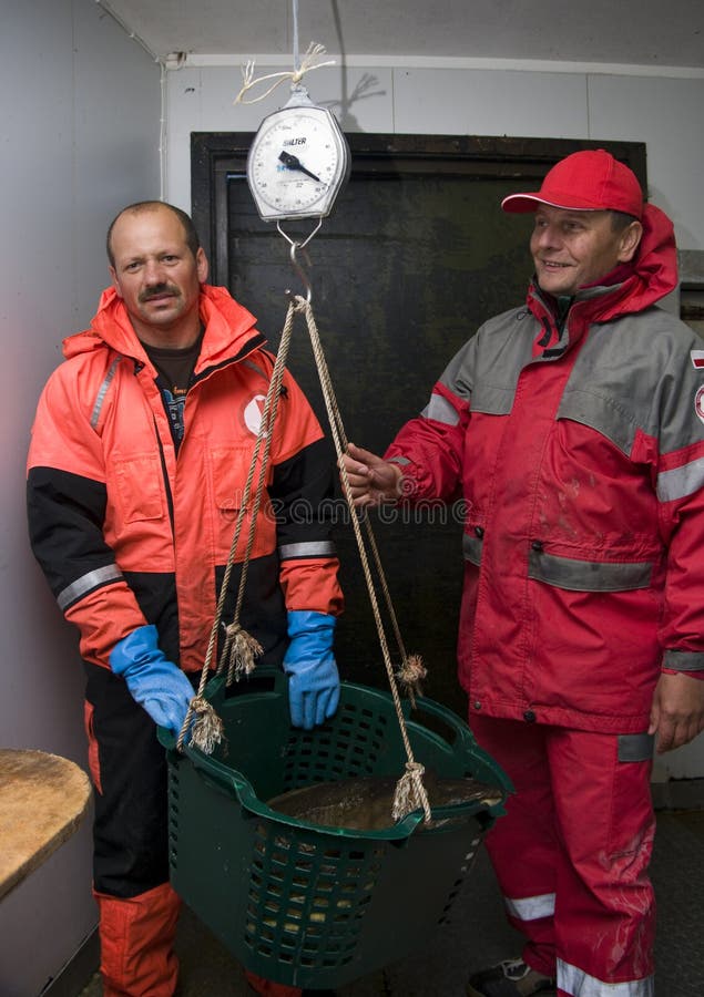 Pescatori che pesano cattura