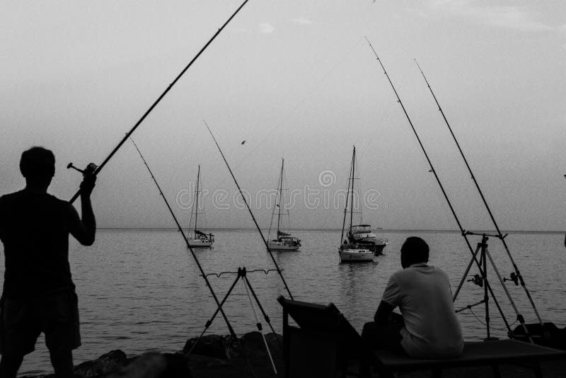 Pesce di cattura del pescatore sulla costa dell'Italia fotografie stock Pesce di cattura del pescatore sulla costa dell'Italia fotografie stock