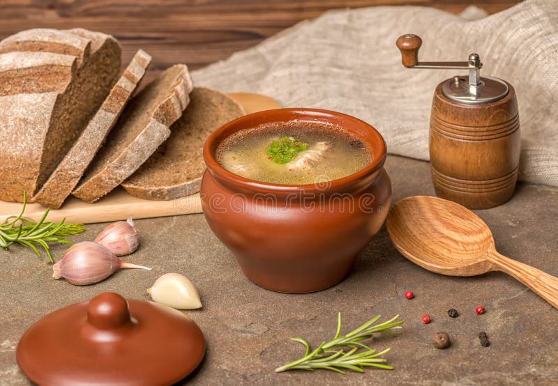 Peschi la minestra con lo storione, patate in piatto dell'argilla, garli decorato immagini stock Peschi la minestra con lo storione, patate in piatto dell'argilla, garli decorato immagini stock