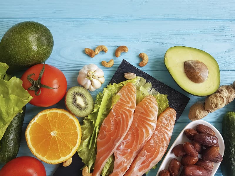 Peschi la salute di color salmone della cena del cibo su un fondo di legno blu differente immagine stock Peschi la salute di color salmone della cena del cibo su un fondo di legno blu differente immagine stock