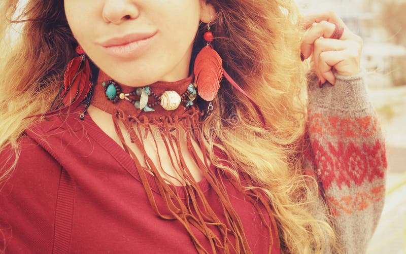 Pescoço e orelhas fêmeas com colar e brincos do boho com penas vermelhas e couro marrom, joia feito a mão fotografia de stock royalty free Pescoço e orelhas fêmeas com colar e brincos do boho com penas vermelhas e couro marrom, joia feito a mão fotografia de stock royalty free