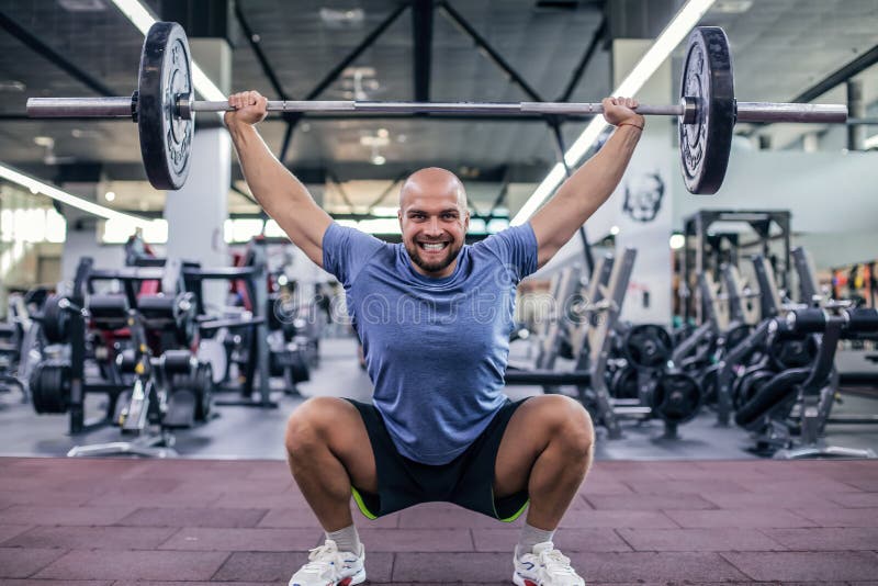 Peso de elevación y griterío Hombre hermoso joven en barbell de elevaci?n de la ropa de deportes en el gimnasio fotos de archivo Peso de elevación y griterío Hombre hermoso joven en barbell de elevaci?n de la ropa de deportes en el gimnasio fotos de archivo