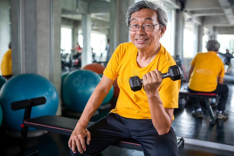 Pesos de levantamento do homem asiático superior do esporte no gym da aptidão homem mais velho que exercita, dando certo, pesos d