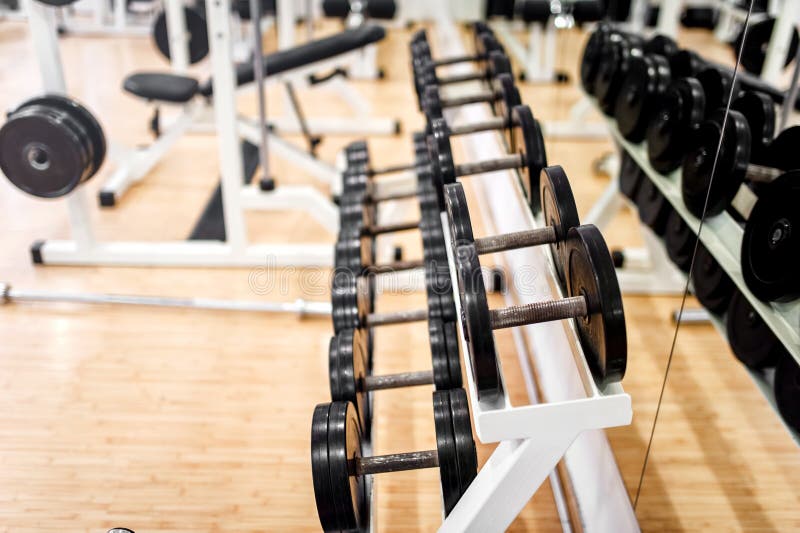Pesos no clube desportivo, no gym ou no fitness center moderno imagens de stock royalty free Pesos no clube desportivo, no gym ou no fitness center moderno imagens de stock royalty free