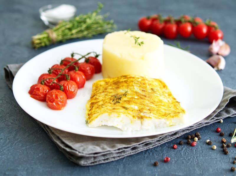 Pesque el bacalao cocido en horno con los purés de patata, tomates, adiete la comida sana Fondo gris oscuro, vista lateral fotografía de archivo Pesque el bacalao cocido en horno con los purés de patata, tomates, adiete la comida sana Fondo gris oscuro, vista lateral fotografía de archivo