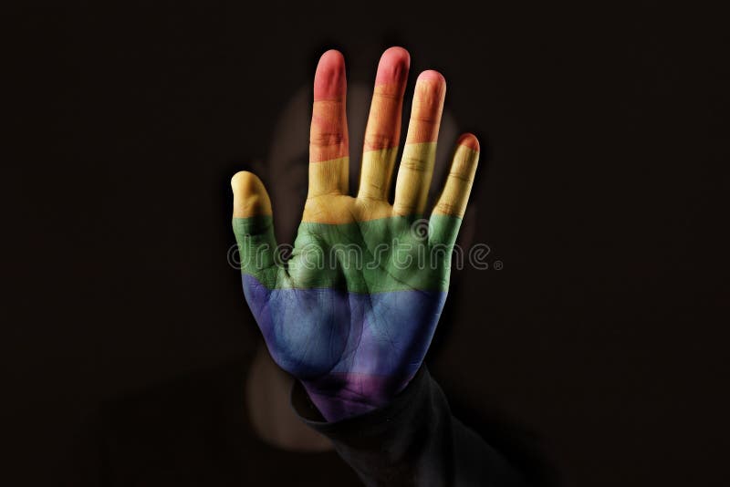Pessoa com a bandeira do arco-íris em sua mão imagem de stock Pessoa com a bandeira do arco-íris em sua mão imagem de stock