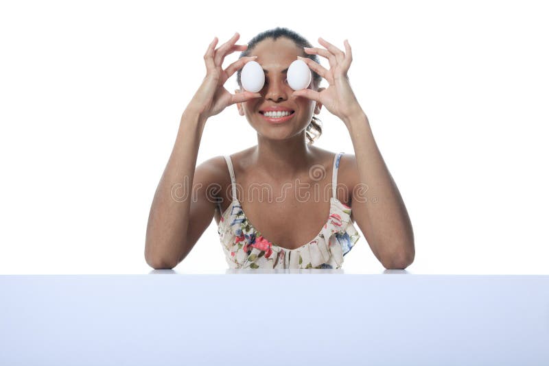 Pessoa do mulato que come o ovo dois na frente do olho imagens de stock Pessoa do mulato que come o ovo dois na frente do olho imagens de stock