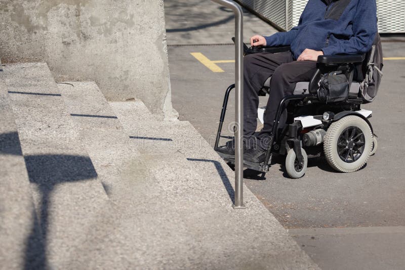 Jovem sozinho em cadeira de rodas nas escadas, problema de deficiência.  pessoas paralisadas e incapacitadas, superação de deficiências. homem  deficiente e indefeso caminhando no parque