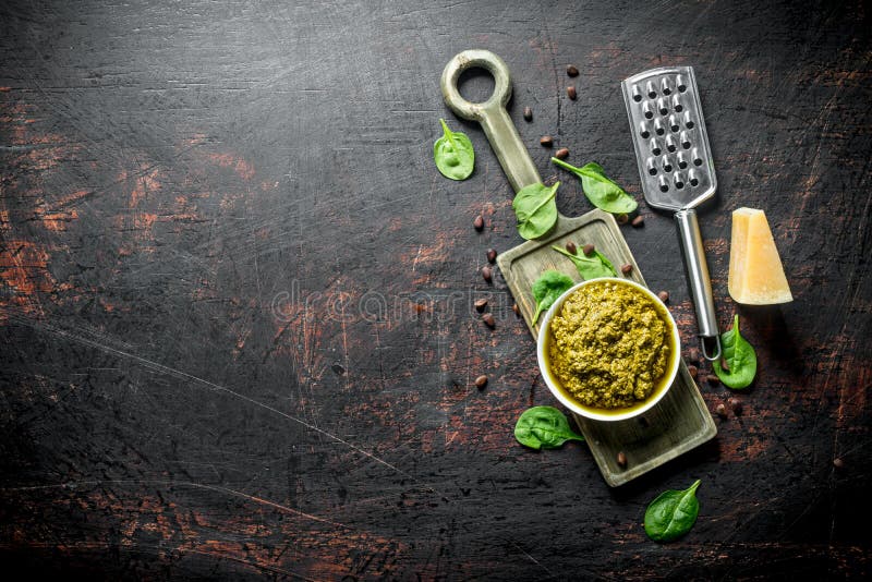 Pesto kumberland na tnącej desce z dokrętkami i basilem Parmezańskimi, sosnowymi, obrazy royalty free Pesto kumberland na tnącej desce z dokrętkami i basilem Parmezańskimi, sosnowymi, obrazy royalty free