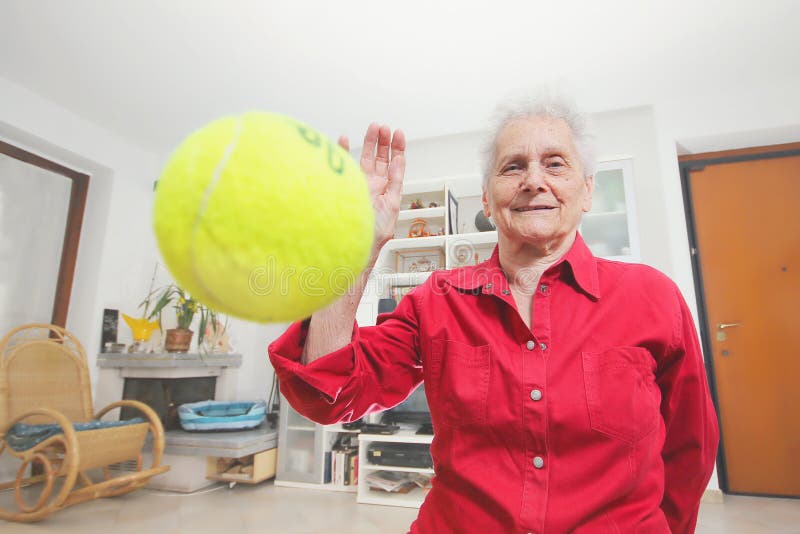 Pet s prospective. Grandmother paly wits a tennis ball.
