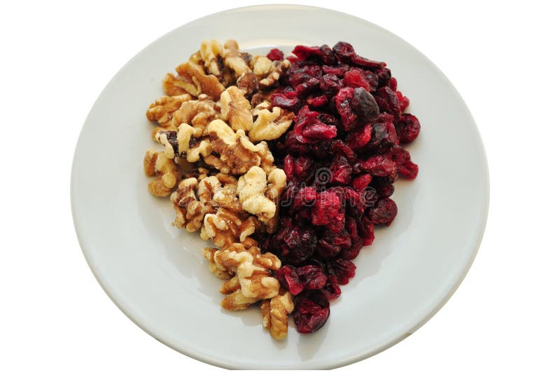 Dried Cranberries with walnuts on a white plate in a heart shape present themselves as a healthy snack. Dried Cranberries with walnuts on a white plate in a heart shape present themselves as a healthy snack.