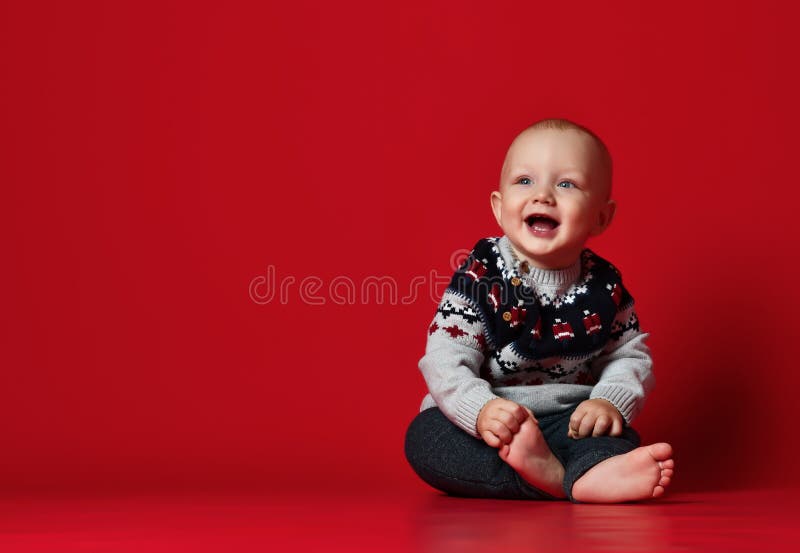 Petit bébé drôle utilisant le chandail tricoté chaud de Noël au studio le jour froid d'hiver photos stock Petit bébé drôle utilisant le chandail tricoté chaud de Noël au studio le jour froid d'hiver photos stock