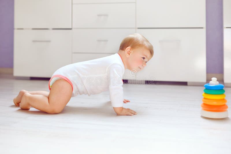Petit bébé mignon apprenant à ramper Enfant en bonne santé rampant dans la chambre d'enfants Fille en bonne santé heureuse de sou photo stock Petit bébé mignon apprenant à ramper Enfant en bonne santé rampant dans la chambre d'enfants Fille en bonne santé heureuse de sou photo stock