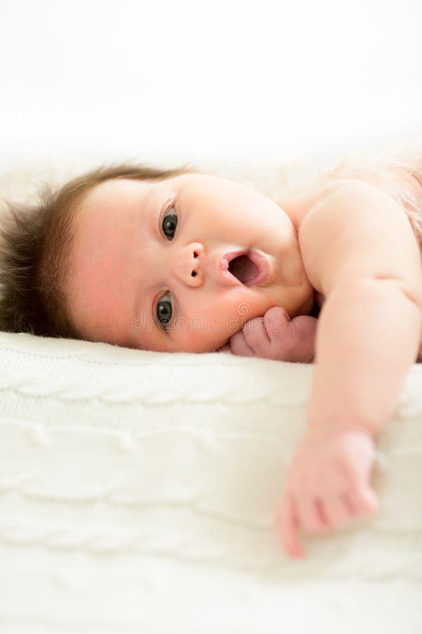 Petit bébé se trouvant sur le lit blanc photo libre de droits Petit bébé se trouvant sur le lit blanc photo libre de droits