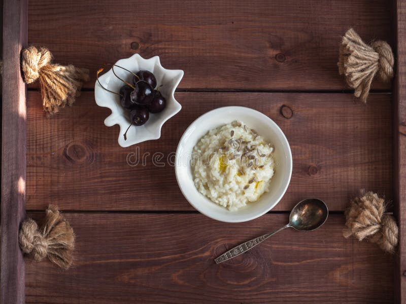 Petit déjeuner blanc de gruau de lait de riz avec des graines de tournesol et des baies de cerise en gaufrettes blanches sur un p photo stock Petit déjeuner blanc de gruau de lait de riz avec des graines de tournesol et des baies de cerise en gaufrettes blanches sur un p photo stock