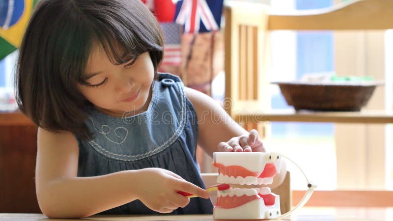 Petit enfant asiatique balayant la fausse mâchoire