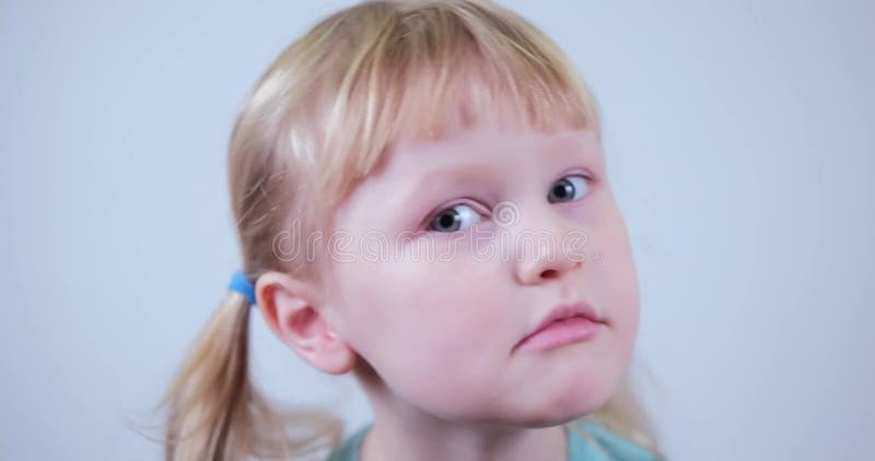Petit enfant curieux blond portrait fille. drôle visage enfant contemplatif enfant. banque de vidéos