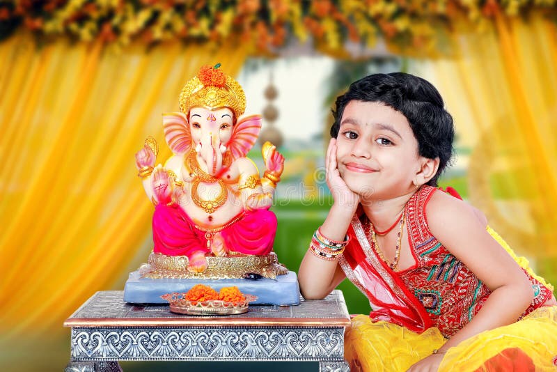 Petit enfant indien de fille avec le ganesha et la prière de seigneur, festival indien de ganesh photo libre de droits Petit enfant indien de fille avec le ganesha et la prière de seigneur, festival indien de ganesh photo libre de droits