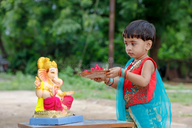 Petit enfant indien de fille avec le ganesha et la prière de seigneur, festival indien de ganesh photo stock Petit enfant indien de fille avec le ganesha et la prière de seigneur, festival indien de ganesh photo stock