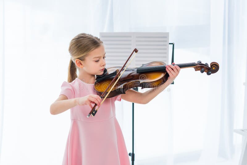 petit enfant mignon dans la robe rose jouant le violon photo libre de droits petit enfant mignon dans la robe rose jouant le violon photo libre de droits