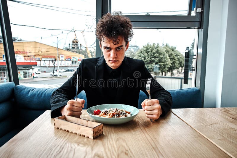 Petit entrepreneur réussi prenant le déjeuner dans un restaurant de luxe photographie stock Petit entrepreneur réussi prenant le déjeuner dans un restaurant de luxe photographie stock