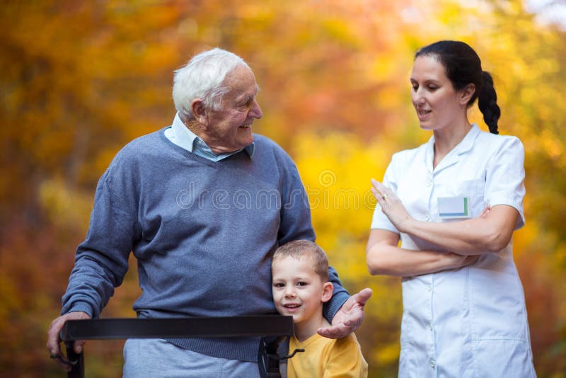 Jeune petit-fils passant le temps en parc avec le grand-père supérieur handicapé