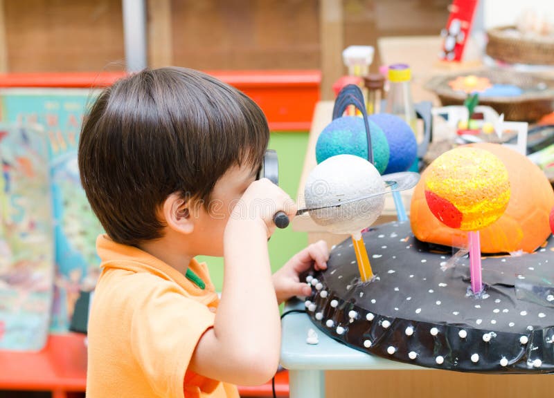 Petit garçon apprenant le regard dans l'espace dans la classe photos libres de droits Petit garçon apprenant le regard dans l'espace dans la classe photos libres de droits