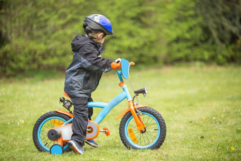 Petit garçon apprenant à monter le premier vélo images stock Petit garçon apprenant à monter le premier vélo images stock