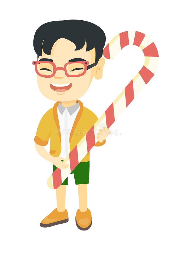 Petit garçon asiatique tenant la canne de sucrerie de Noël